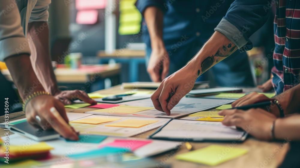 brainstorming with the creative team in the office with papers statistics and stickynotes brainstorming with the creative team in the office with papers statistics and stickynotes