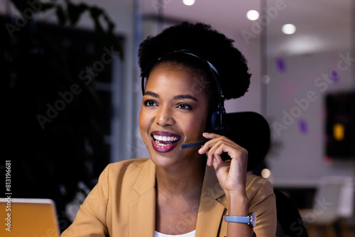 Working late at office, African American businesswoman wearing headset