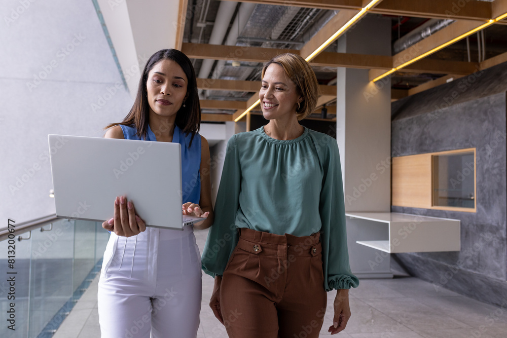 Diverse team members walking together at office, sporting straight hair