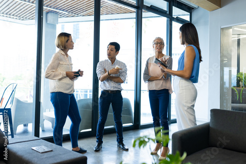 Diverse team members converse in office lobby photo