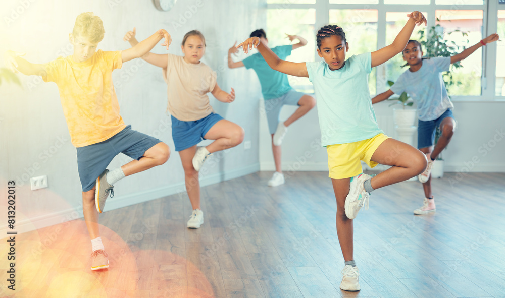 Obraz premium Smiling girls and boys doing dance workout during group class in fitness center