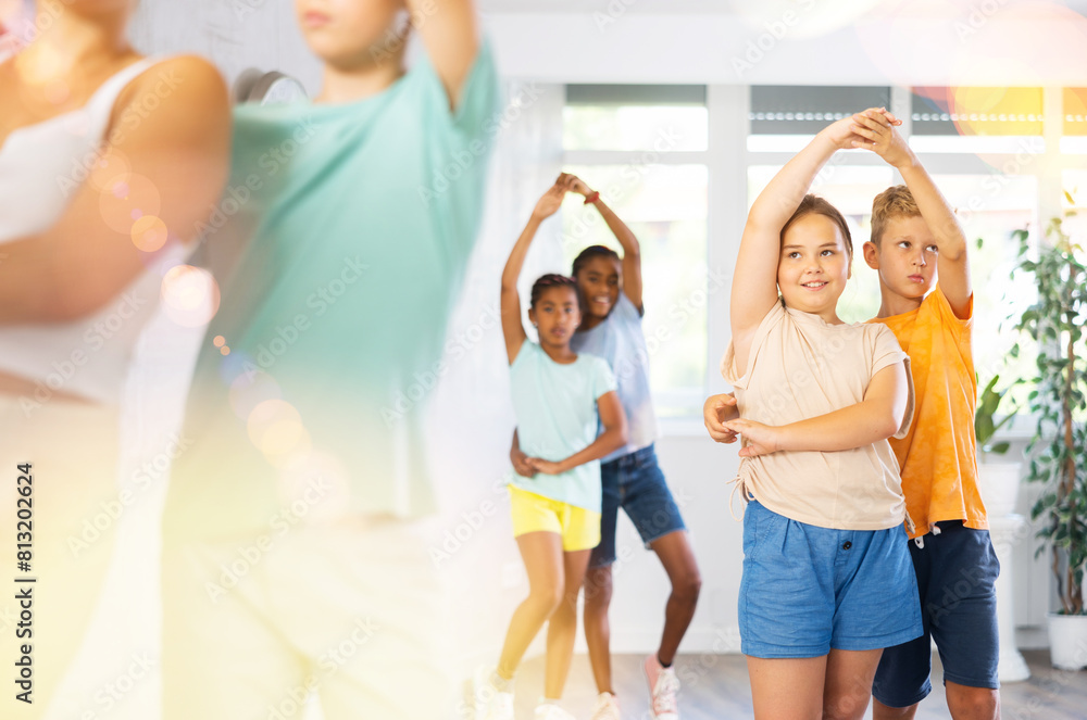 Fototapeta premium Portrait of smiling girl with boy performing pair dance movements