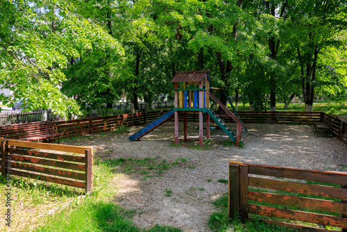 A playground with wooden fence and a wooden play structure