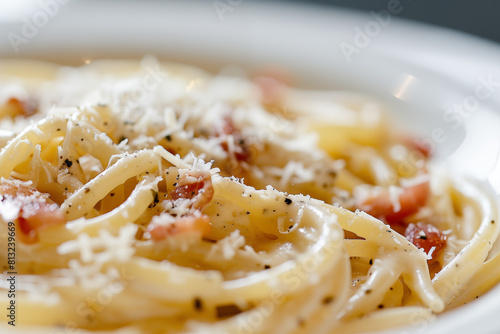 Macro super detailed shot of a spaghetti carbonara plate with bacon and grated cheese.