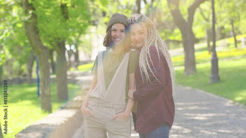 Lesbian girlfriends are happy in golden hour in park. Hugging LGBTQ women,gay couple
