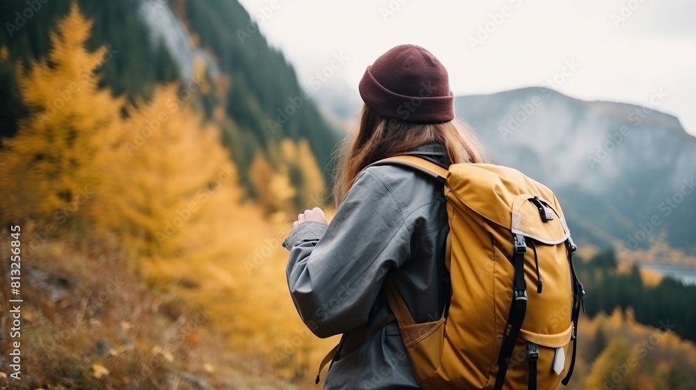 Fototapeta premium Rear view of a woman walking up a mountain.woman with backpack travels in the mountains
