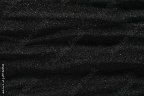 Dunes of dark black sand. Stripes and ripples of smooth volcanic sand texture or wallpaper. Wave pattern in black sand background. © Leigh Prather