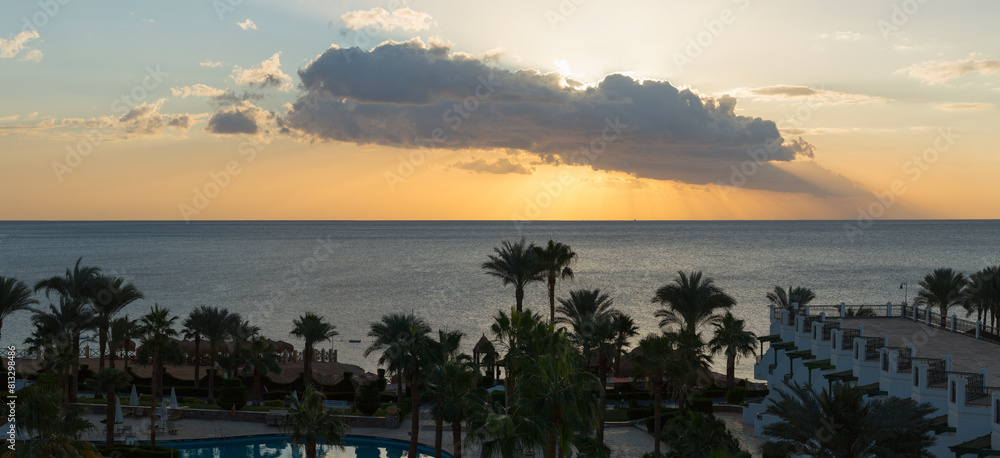 Obraz premium Sunrise on the sea coast. The movement of the sun and clouds across the sky. Park recreation areas of Egypt. Garden and landscape design.
