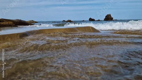 Ocean waves eroding sandy coastal beach, low angle view