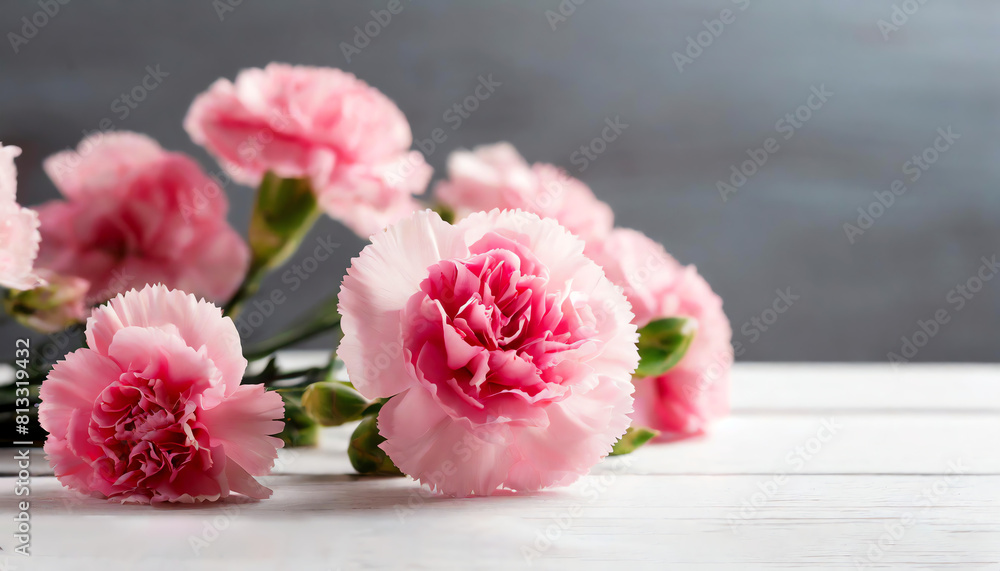 Pink carnations and white wooden background