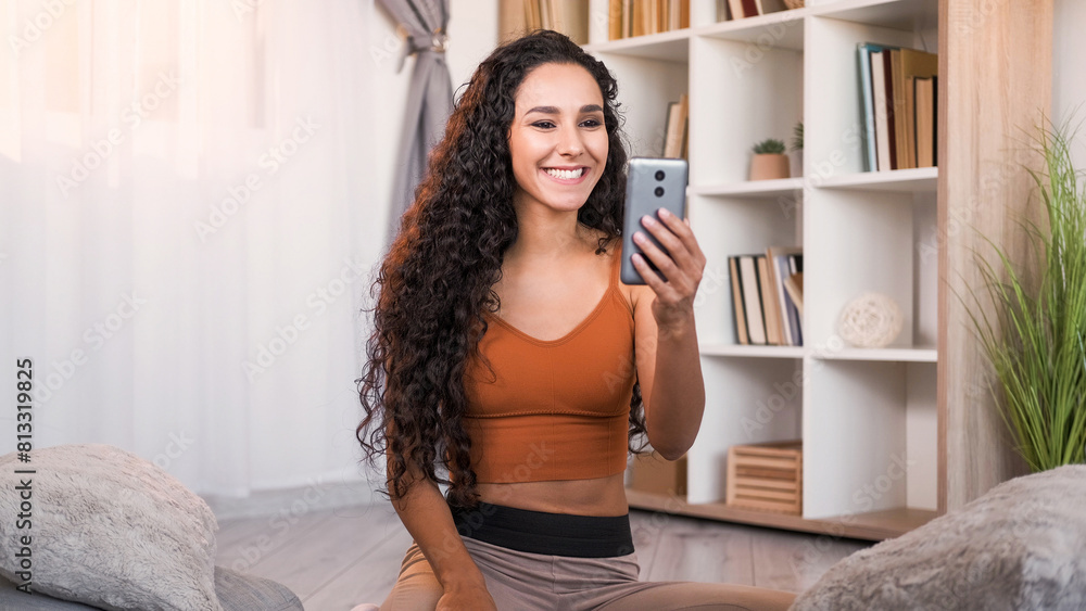 Video call. Mobile communication. Distance meeting. Happy cheerful woman enjoying talking on phone online at light modern home interior with free space. Video call. Mobile communication. Distance meeting. Happy cheerful woman enjoying talking on phone online at light modern home interior with free space.