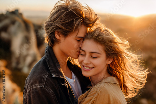 Young couple embracing and kissing at sunset on a hilltop, expressing love and intimacy in a serene natural setting