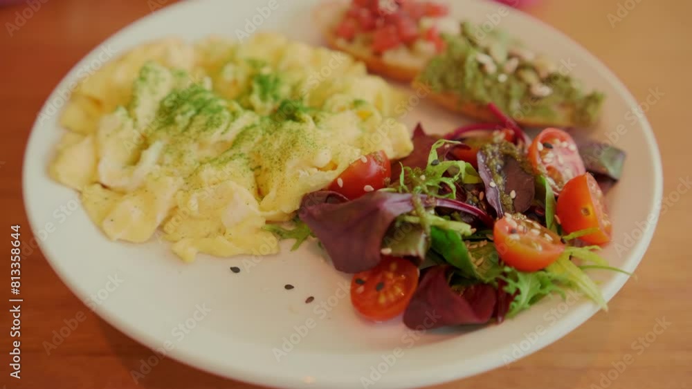 A nutritious brunch serving with fluffy scrambled eggs, a vibrant mixed salad, avocado toast, and seeds. A nutritious brunch serving with fluffy scrambled eggs, a vibrant mixed salad, avocado toast, and seeds.