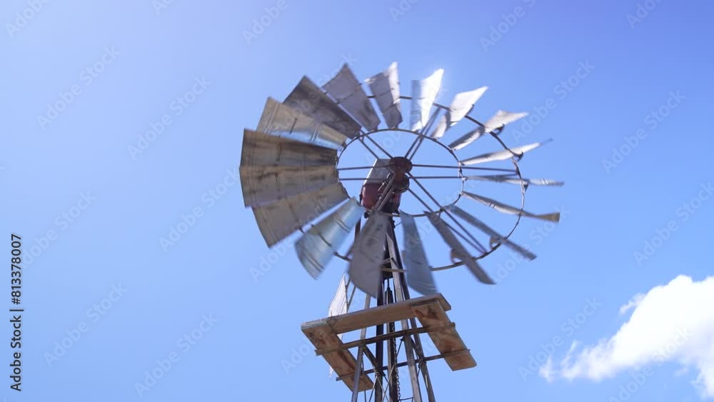 The windmill as its blades rotate, powered by the wind.