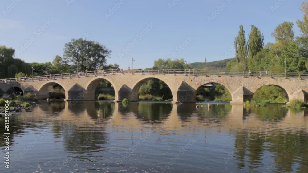 Tranquil scene of an ancient stone bridge reflecting in calm water on a sunny day Tranquil scene of an ancient stone bridge reflecting in calm water on a sunny day