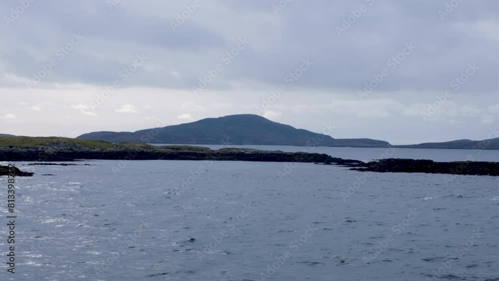 Scenic view of remote, rugged and rocky islands with birds traveling on passenger ferry from Barra to South Uist in the Outer Hebrides of Scotland UK Scenic view of remote, rugged and rocky islands with birds traveling on passenger ferry from Barra to South Uist in the Outer Hebrides of Scotland UK