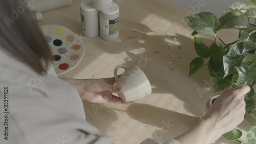 A female ceramicist painting on clay photo