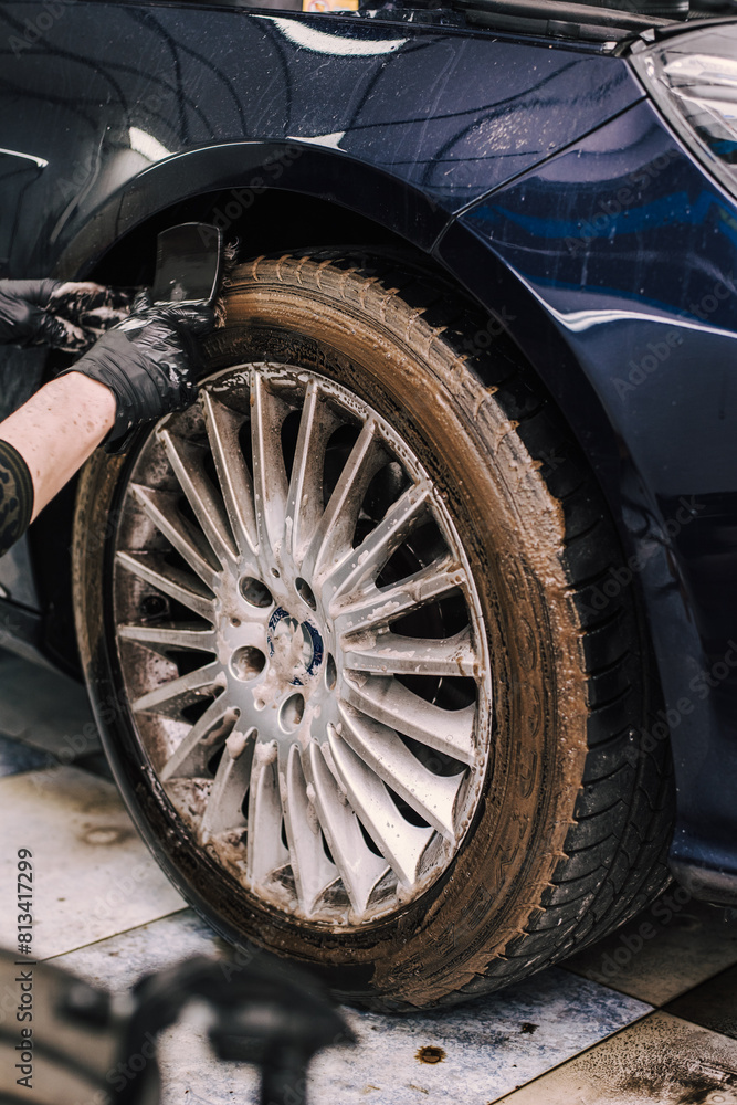 Person wearing gloves cleaning a tire