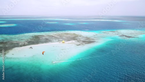 Kite surfers gliding on the turquoise waters around sardina island, showcasing serene tropical beauty, aerial view