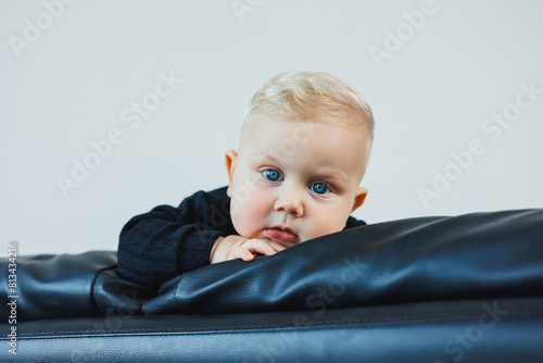 6 months old cute Caucasian and African mixed race baby coughing. He is sitting on his high chair having his first solid food