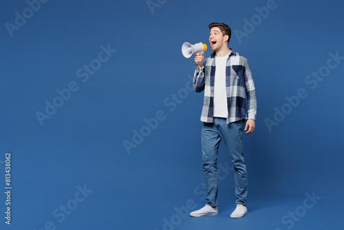 Full body young man he wear shirt white t-shirt casual clothes hold in hand megaphone scream announces discounts sale Hurry up isolated on plain blue cyan background studio portrait Lifestyle concept
