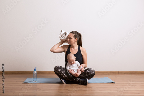 Woman resting after home mommy and me workout. Physical activity for mother while bonding with children. photo