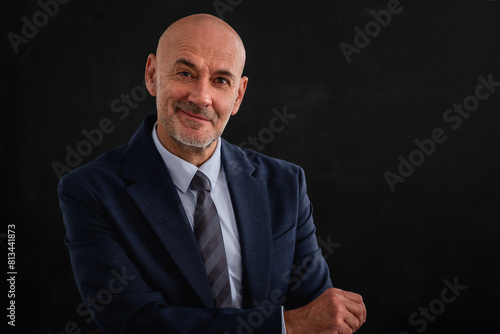 Mid aged man studio portrait at isolated dark background