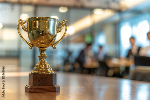 a golden trophy stands on a table on a blurred background of a team of businessmen in a conference room 