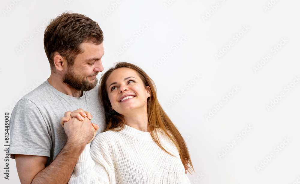 Happy loving young adult couple hugging on white background. Heterosexual couple in love. Happy loving young adult couple hugging on white background. Heterosexual couple in love.