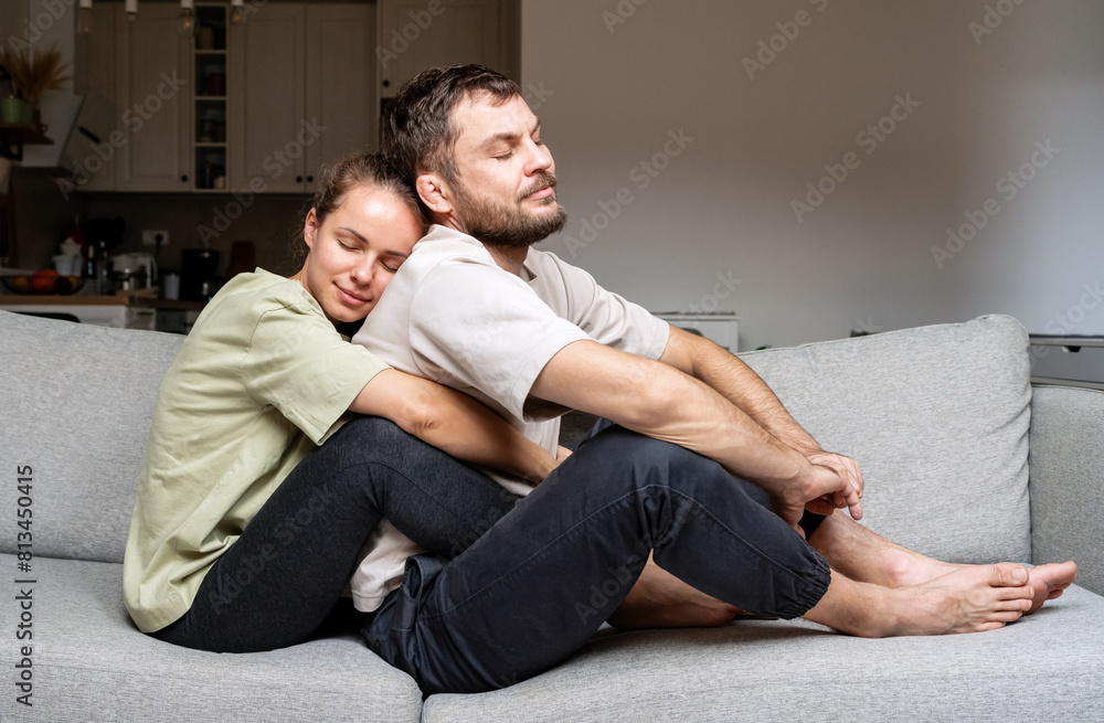 Young adult married couple together at home. Woman hugs her husband. Family support and care. Young adult married couple together at home. Woman hugs her husband. Family support and care.