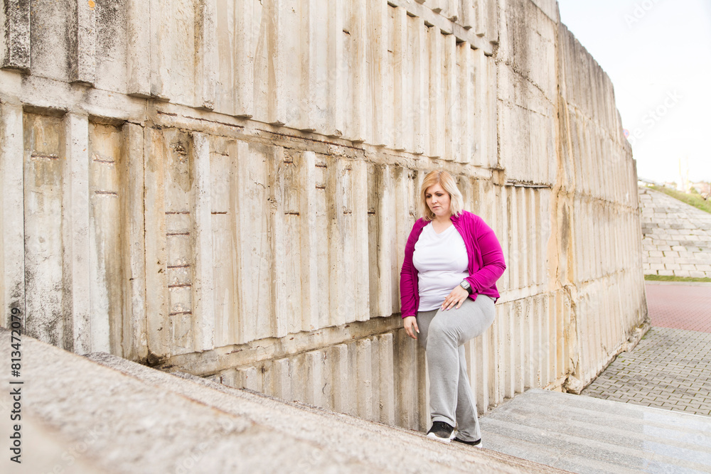 Overweight woman walking up the stairs in city park, down the stairs. Exercising outdoors for people with obesity. Overweight woman walking up the stairs in city park, down the stairs. Exercising outdoors for people with obesity.