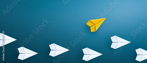 Group of paper plane in one direction and with one yellow paper plane individual pointing in the different way. Business concept for new ideas creativity and innovative solution