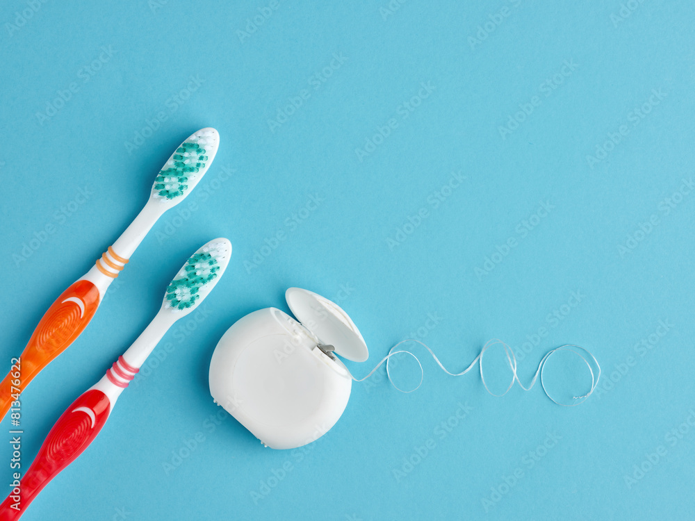 Two toothbrush and a box of dental floss on blue background. Two toothbrush and a box of dental floss on blue background.