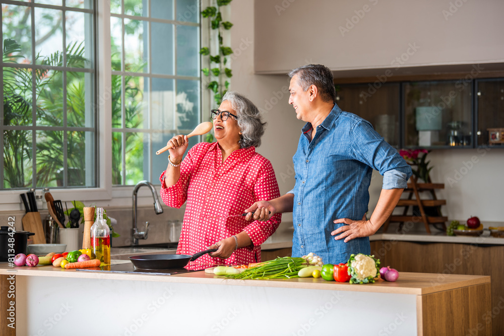 Senior Indian asian couple in kitchen, cooking healthy food together and happy in retirement lifestyle. Senior Indian asian couple in kitchen, cooking healthy food together and happy in retirement lifestyle.