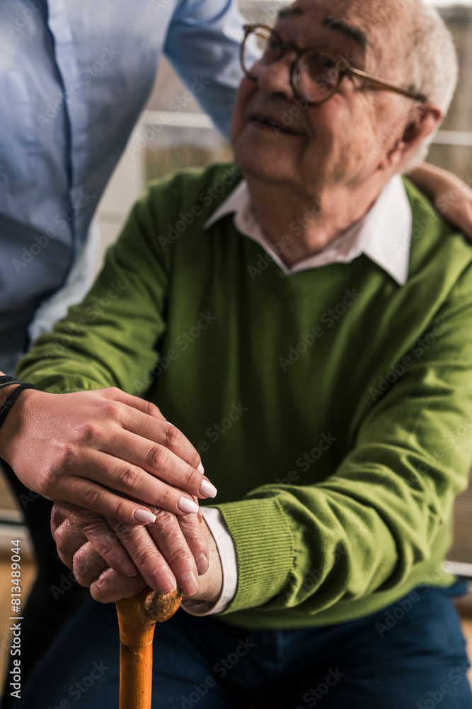 Smiling senior man sitting with nurse at nursing home Smiling senior man sitting with nurse at nursing home