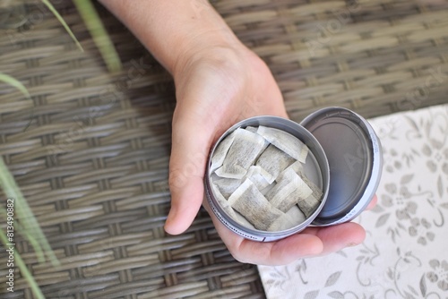 A box of snus pads replaces smokeless cigarettes. Swedish nicotine pouch. A woman holds one bag of snus in her hand.	
 photo