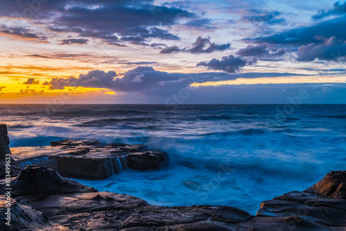 Sunrise  sea  waves  clouds and tessellated rock platform