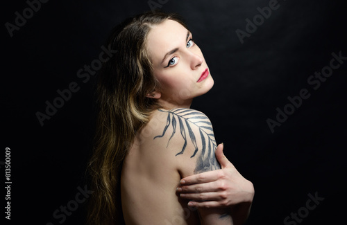 Portrait of beautiful sensual woman with tattoos, close-up. Studio shot.