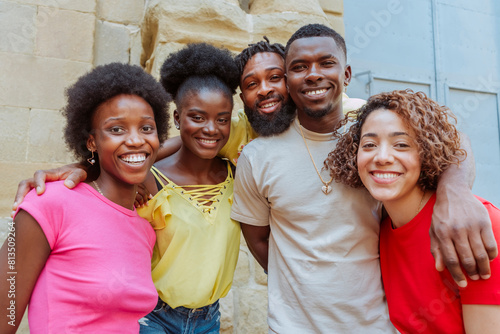 Happy multi ethnic young group of people looking at camera together outdoors - Lifestyle concept with guys and girls having fun hanging out on city street - Cheerful students portrait outside school