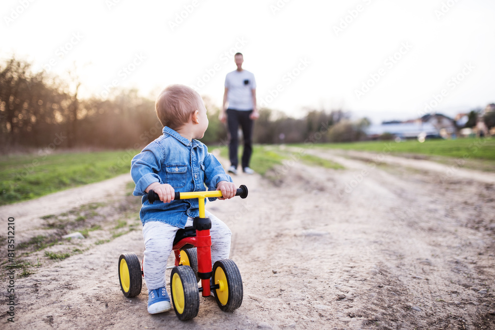 Boy learning ride baby bike, dad helping him. Father's day concept. Boy learning ride baby bike, dad helping him. Father's day concept.