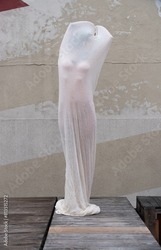 sexy young nude woman in wet white transparent cotton stocking dress as a modern living art sculpture outdoors