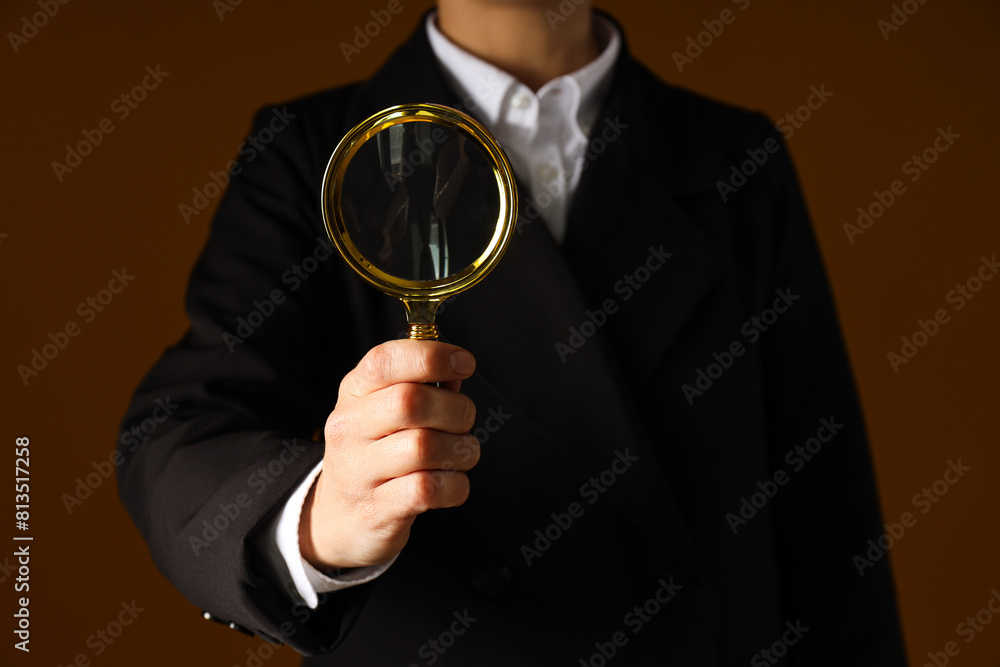 Fototapeta premium A businessman's hand holds a magnifying glass