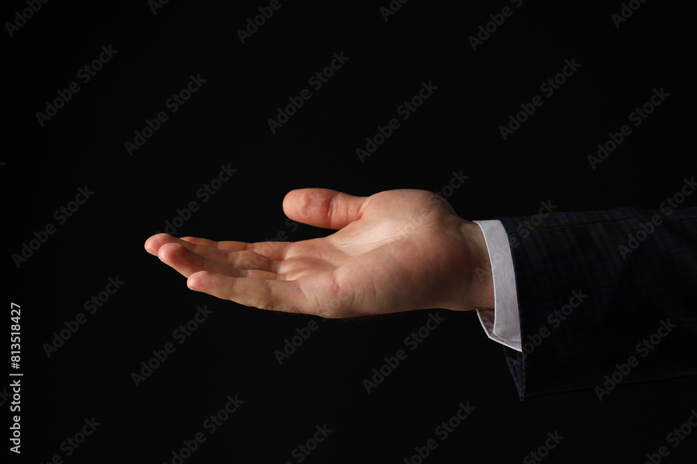Businessman's hand close-up on a black background