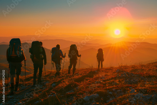 Group of hikers trekking at sunset in mountainous terrain.
