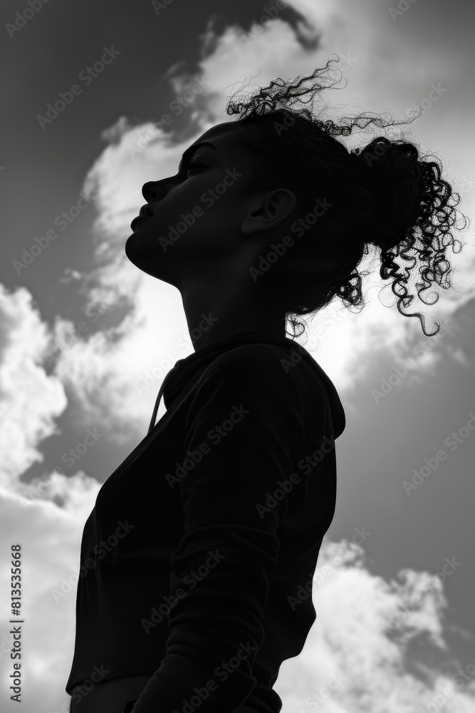 Woman standing in front of a dramatic cloudy sky. Suitable for various concepts and designs Woman standing in front of a dramatic cloudy sky. Suitable for various concepts and designs