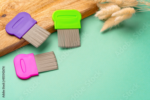 Three combs for lice removing on green background photo