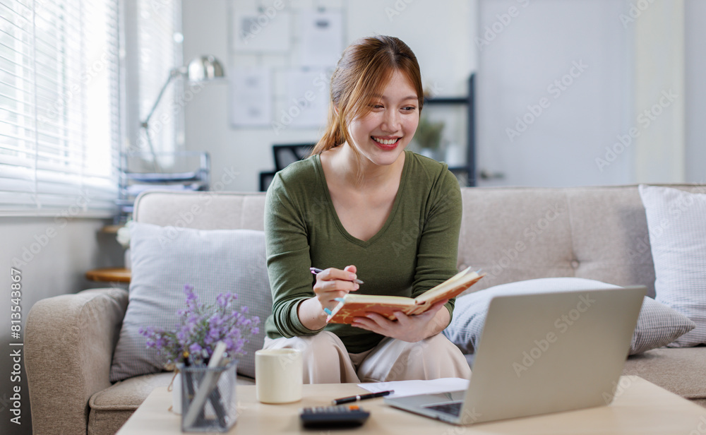 Asian business woman working on a laptop on couch, tax, accounting, statistics and analytical research concept. Asian business woman working on a laptop on couch, tax, accounting, statistics and analytical research concept.