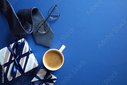 Stylish men’s gift set with coffee, glasses, and tie on blue background - perfect for Happy Fathers Day theme. photo