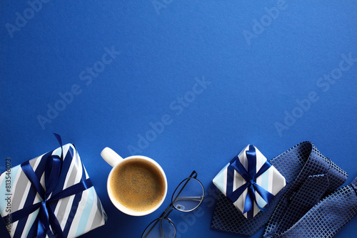 Vibrant blue flat lay with coffee, eyeglasses, and striped gift boxes - ideal for Fathers Day holiday theme