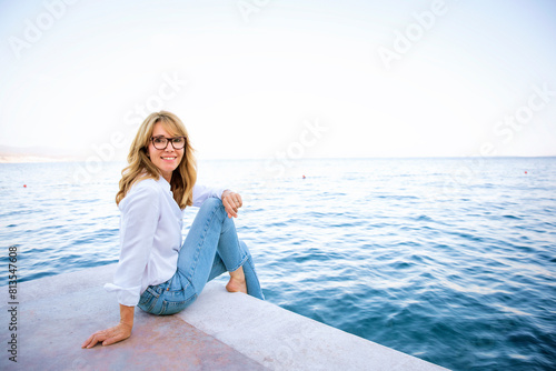 Full length of a mid aged woman relaxing by the sea © sepy